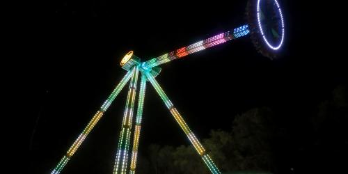 Pendulum swinging ride at night with lights on the ride