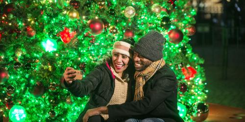 Couple sitting in front of Christmas Tree