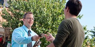 Six Flags offers a variety of services to help make the park experience more enjoyable. Six Flags team member handing out maps to guests